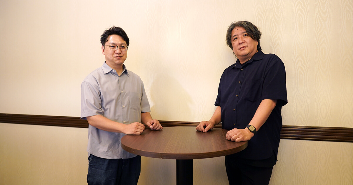 集合写真：プロジェクトマネージャー・シニアディレクター　野島（右）、事業部長　小山（左）