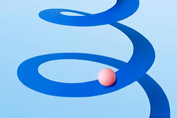 Photo illustration showing a peach colored ball traveling down a blue spiral to symbolize minimum dose of progesterone.thumbnail