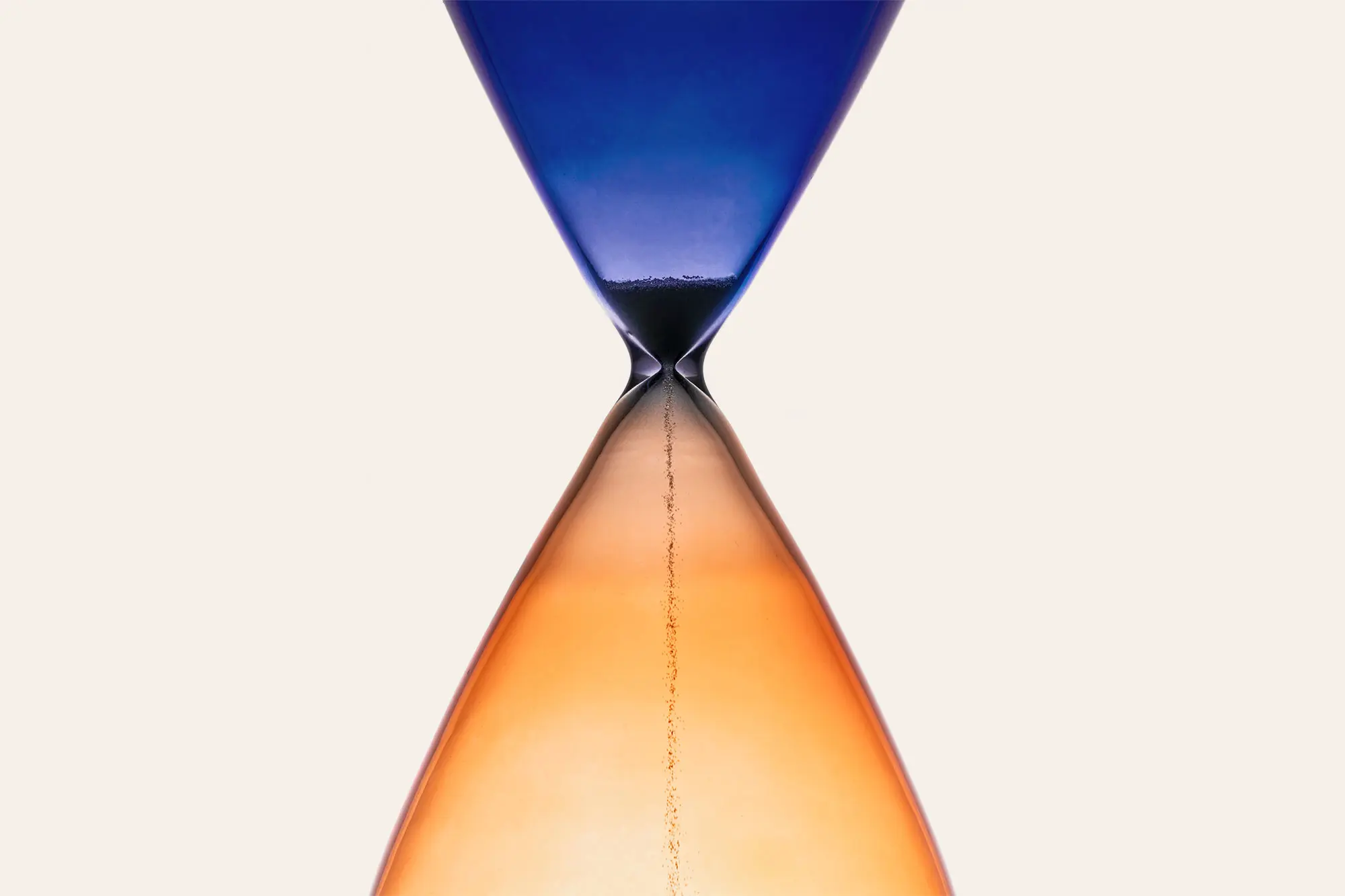 Blue and orange tinted hourglass with sand falling through neck. AW481