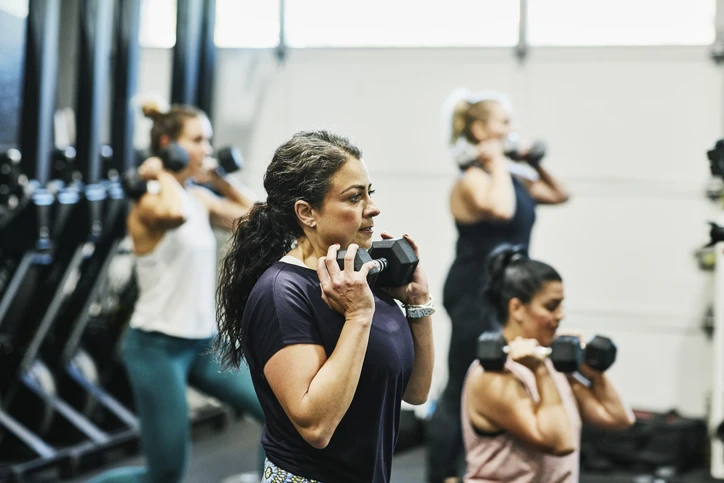 Woman lifting free weights in a gym class. AW283