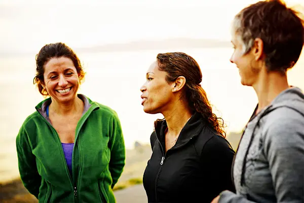 Three women at sunset talking after exercise. AW566