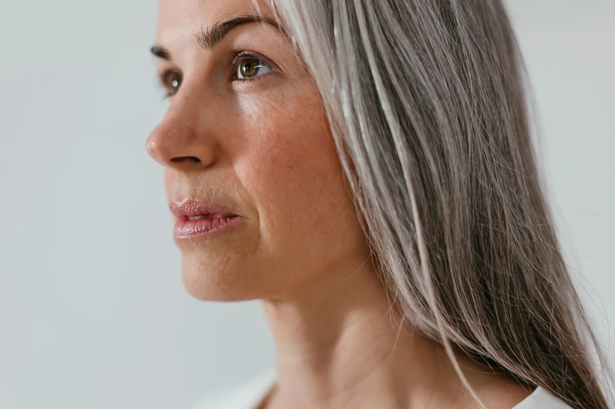 Close-up of woman in profile with long straight grey hair. AW135 