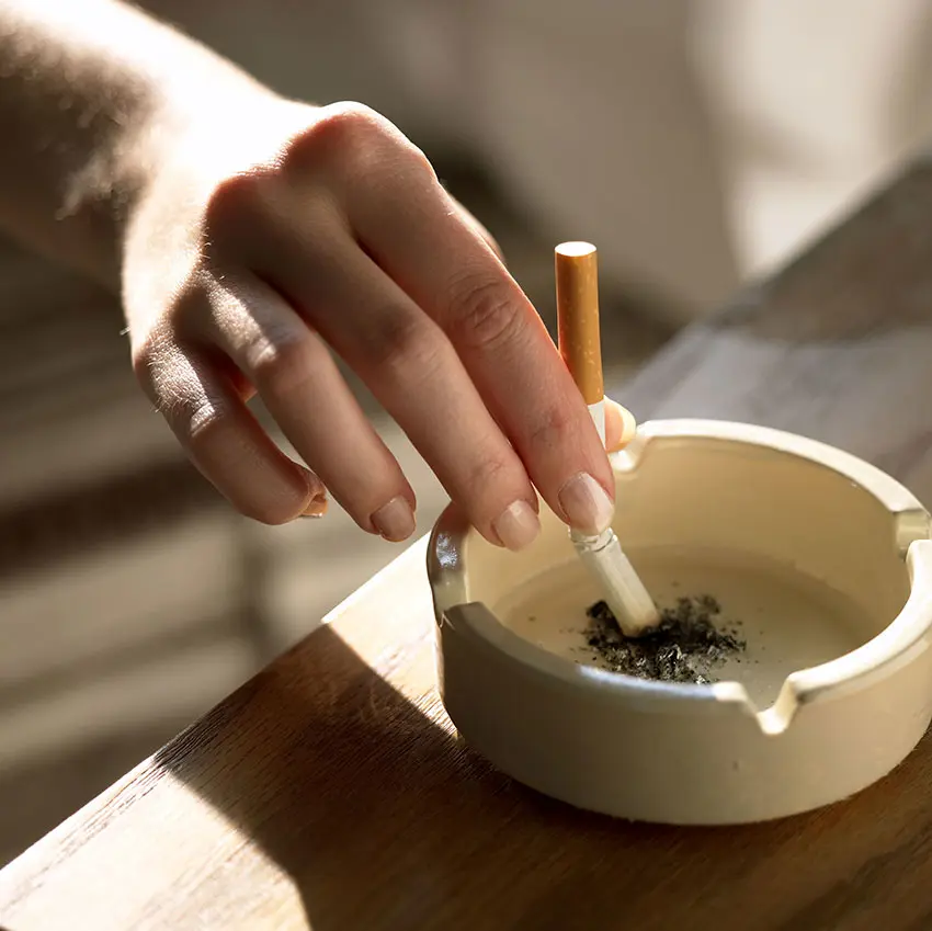 (photo of woman putting cigarette out in ashtray)