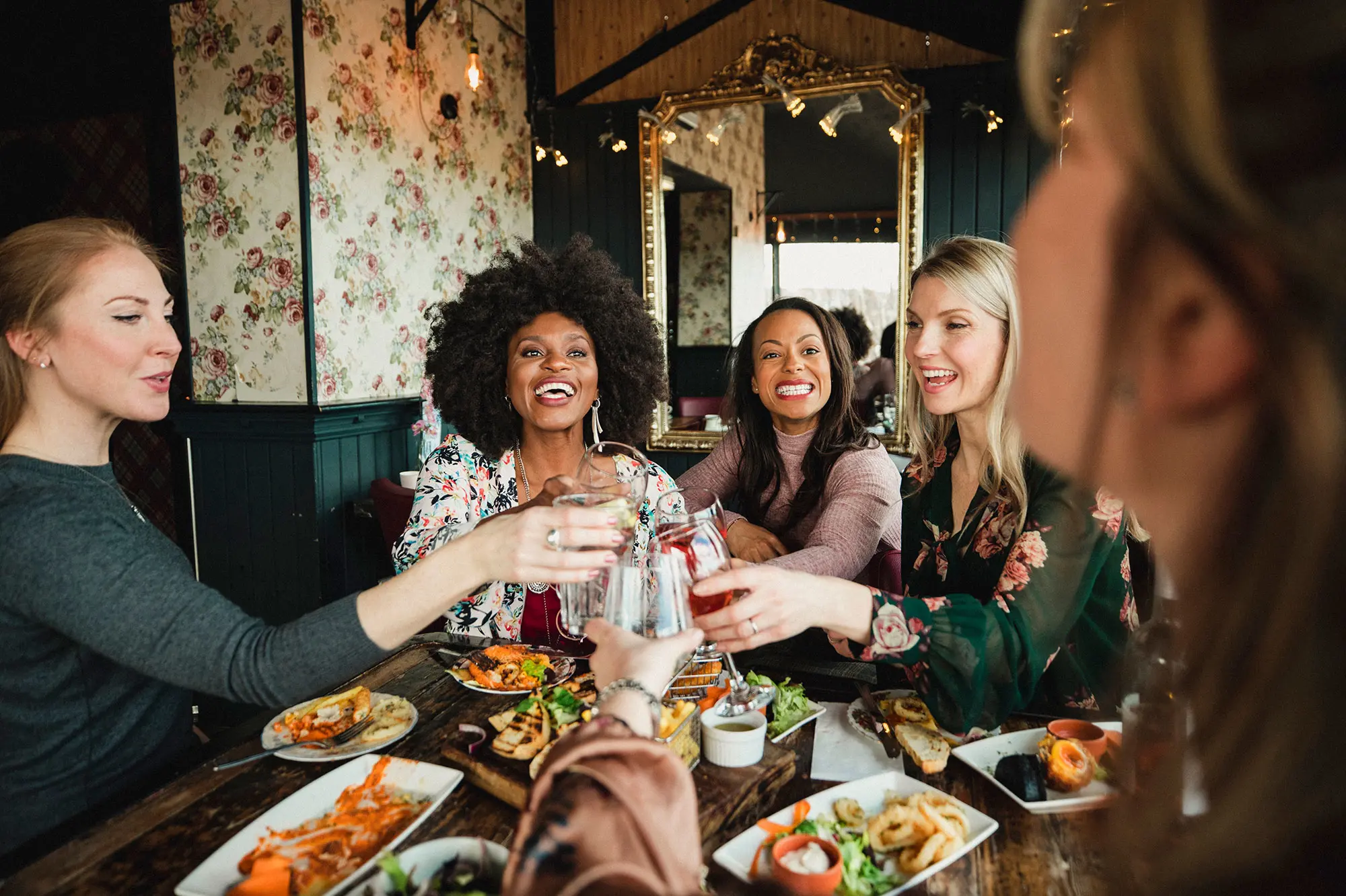 Group of ethnically diverse female friends enjoying alcoholic beverages indoors. AW317 