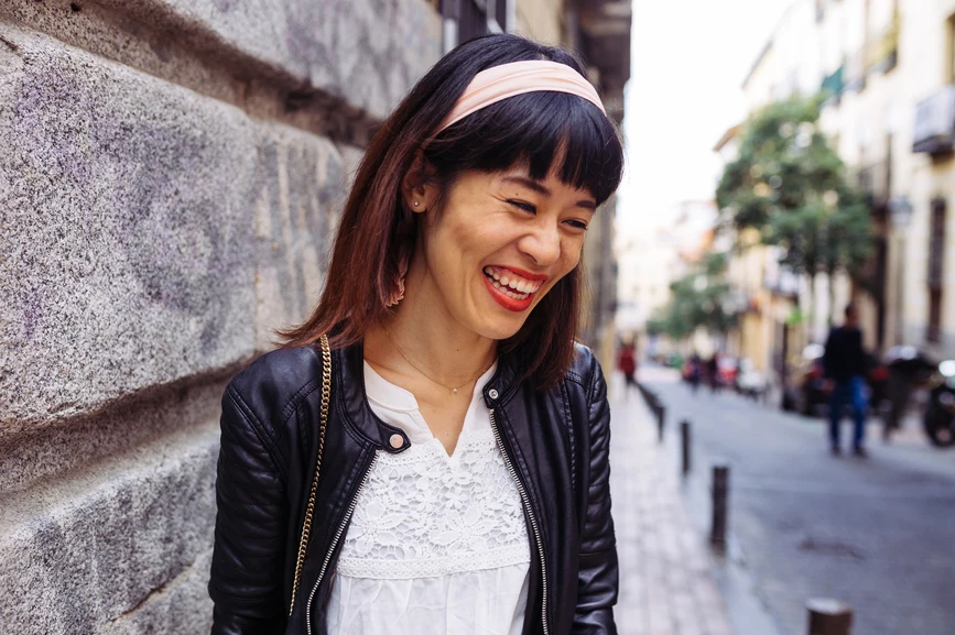 Asian woman laughing on urban street wearing headband. AW159 