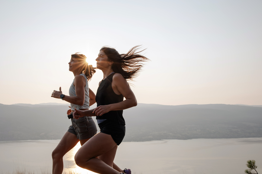 AW280 How to Beat Menopause Fatigue (Photo of two women jogging with sun shining low on the horizon)