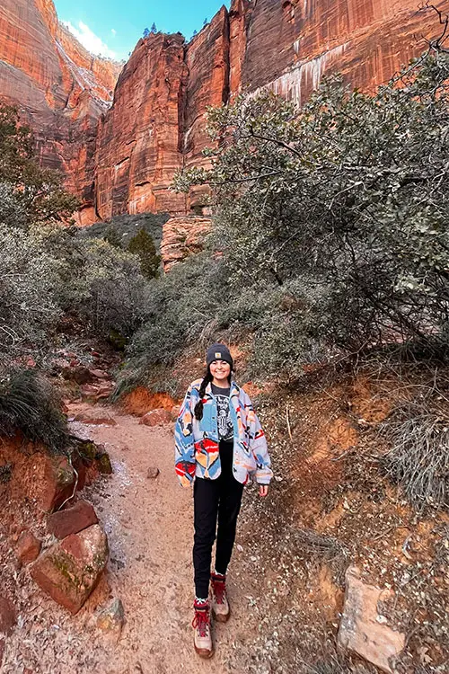 Taryne Stenger amidst canyon landscape in colorful coat.
