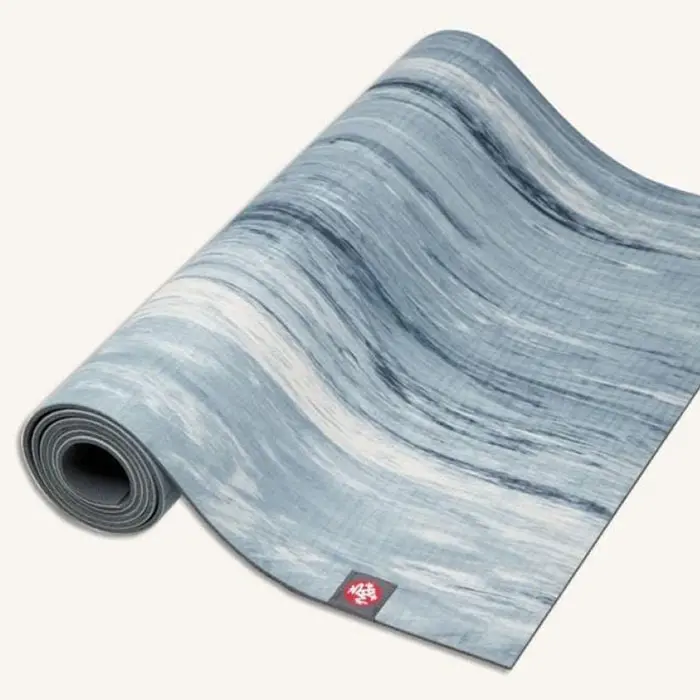 Manduka yoga mat on cream background.