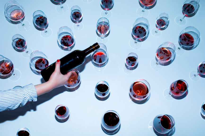 AW093 Hangover Hell (Or Why Can’t I Drink Anymore?) (2) (photo of overhead view - woman pouring red wine into glasses)