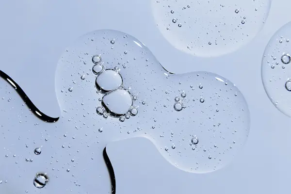 Serum containing peptides in organic pooled shapes on blue background.  thumbnail