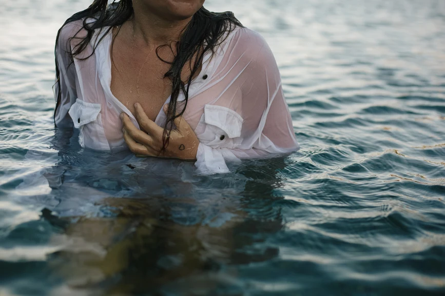 Woman wearing button down shirt standing in water, soaked. AW216 