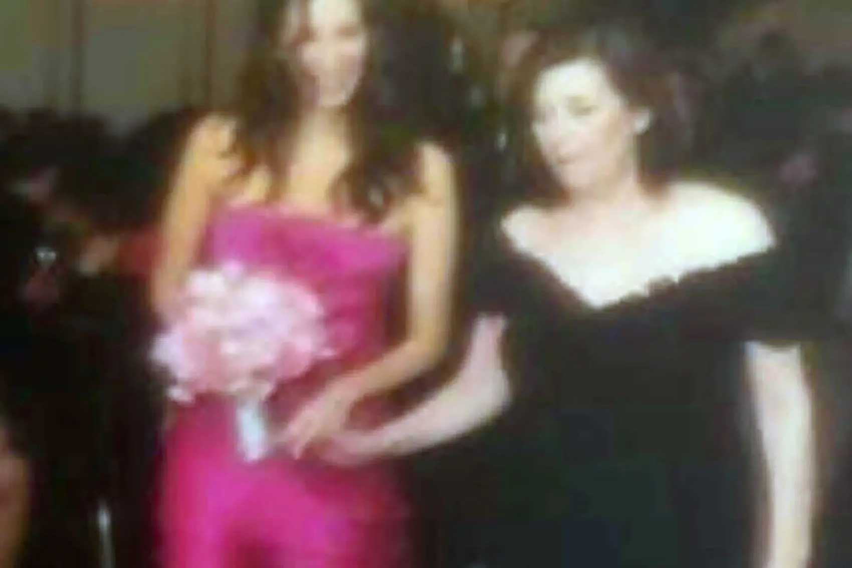 Vintage photo of Randi Friedman and her mother walking down the aisle holding hands with flowers. (header)