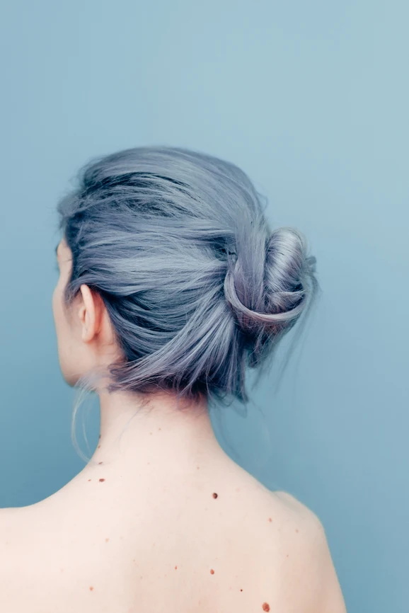 Rear view of woman with bare shoulders, hair dyed blue tied in bun. AW161 
