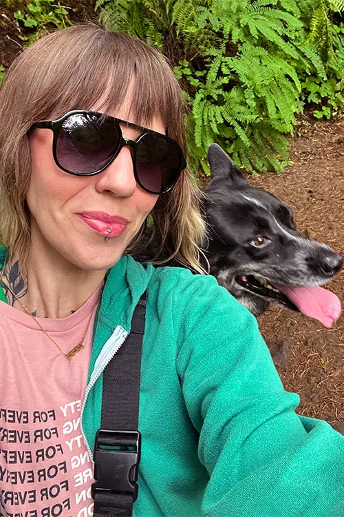 Chantee Willis wearing sunglasses on a hike with her dog.