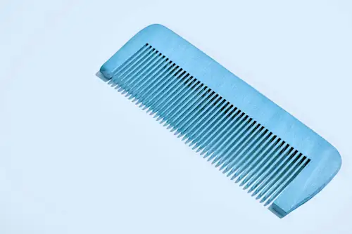 Blue wooden Comb on pale blue background AW615