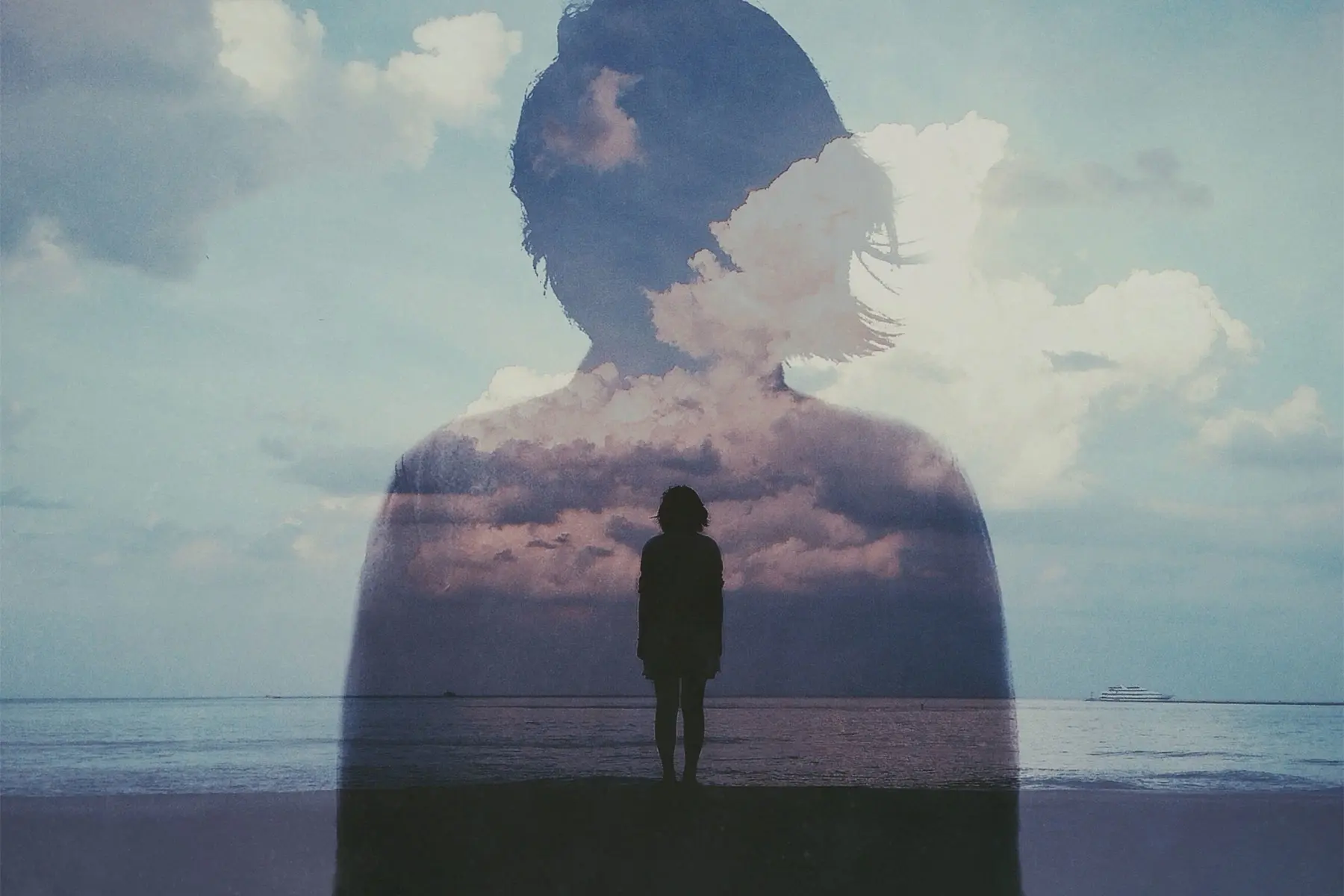 Double exposed photo of a woman on cloudy beach with her own figure in distance.  AW546 