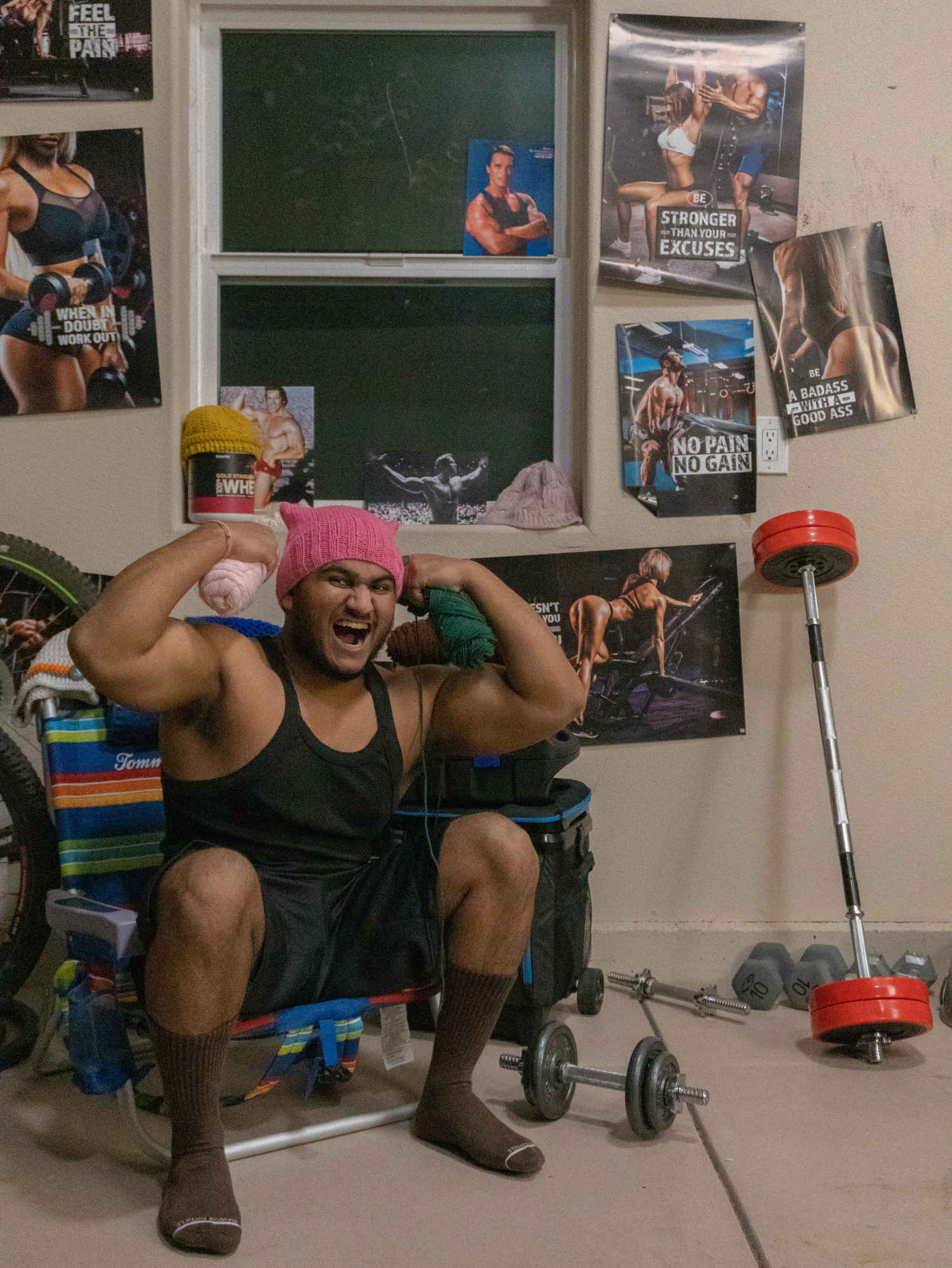 A man sitting on a chair in a room full of weights.