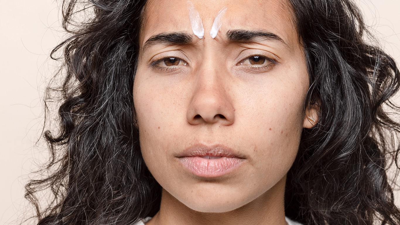 Woman with skincare cream on forehead closeup