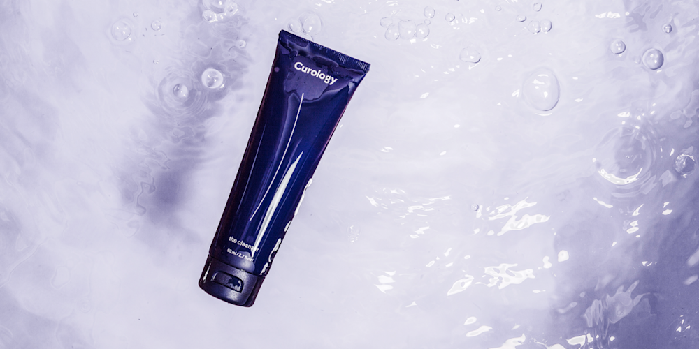 Curology bottle floating in purple water