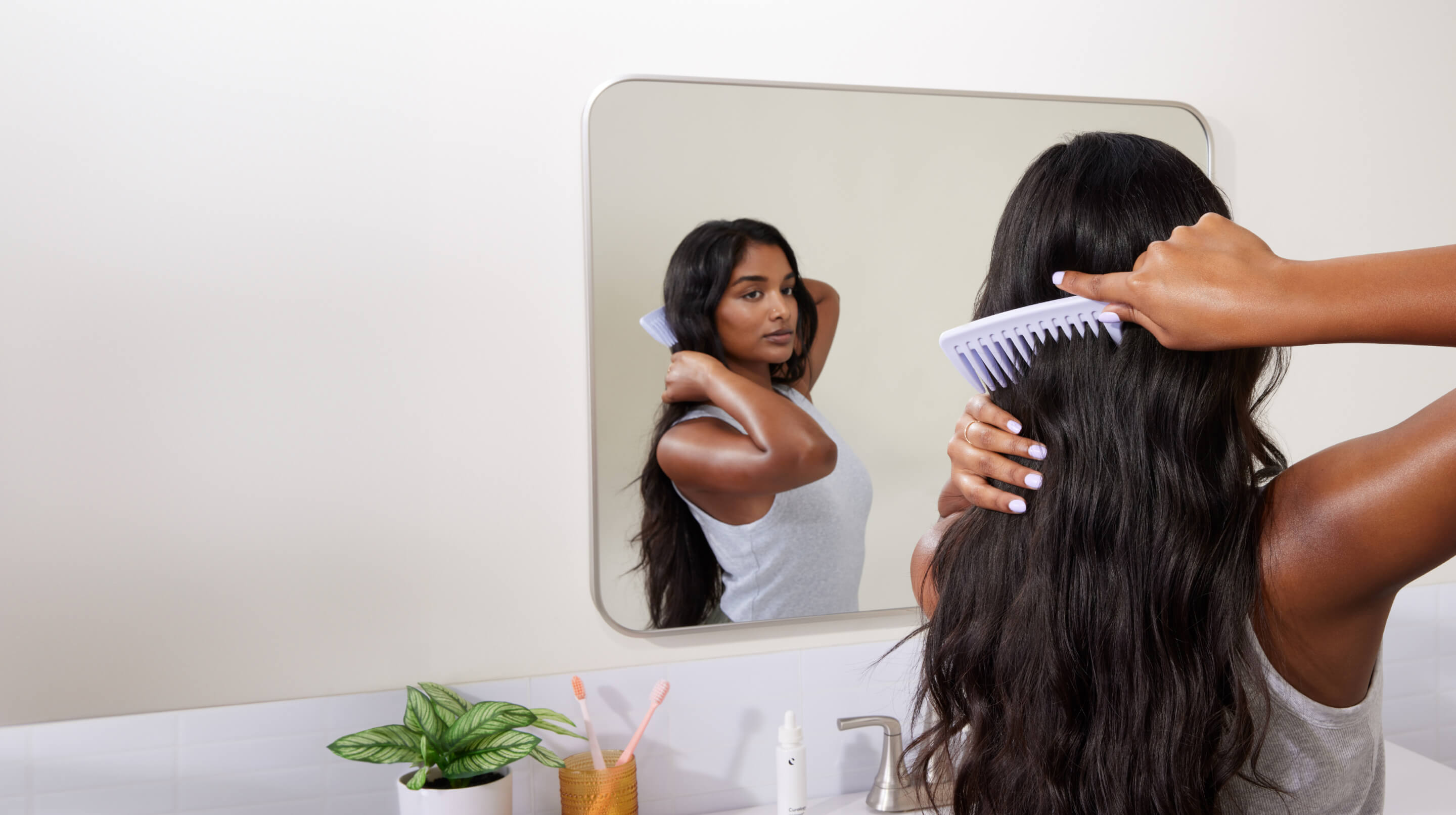 Brunette combing hair in mirror - Mobile