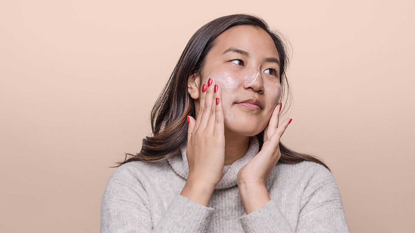 Woman adding skincare cream to her face