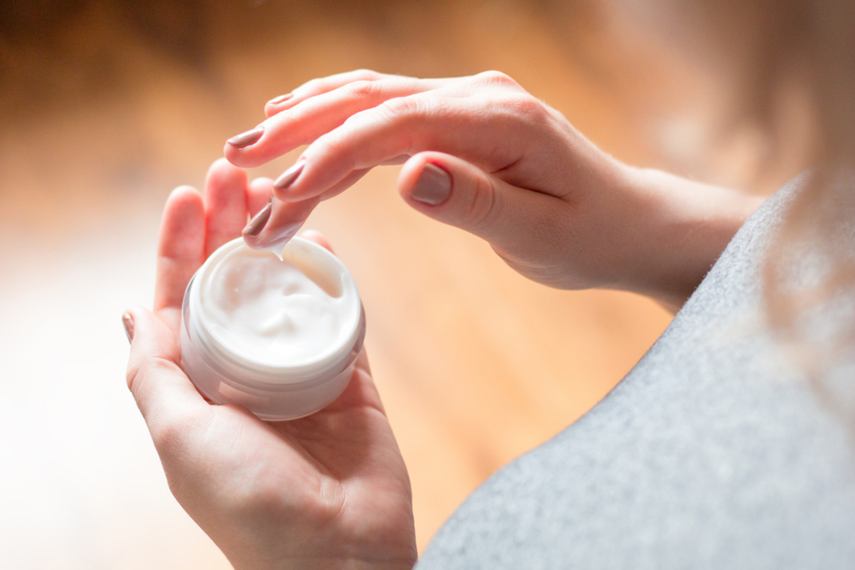 Woman using body care cream