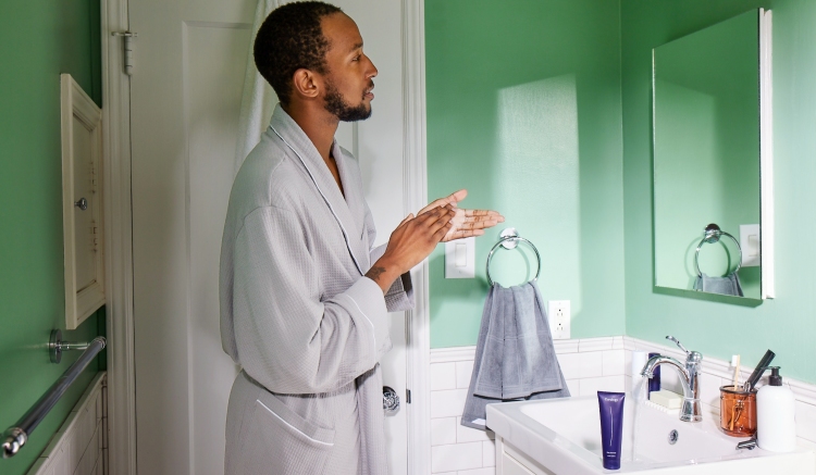 Man cleansing with Curology in bathroom