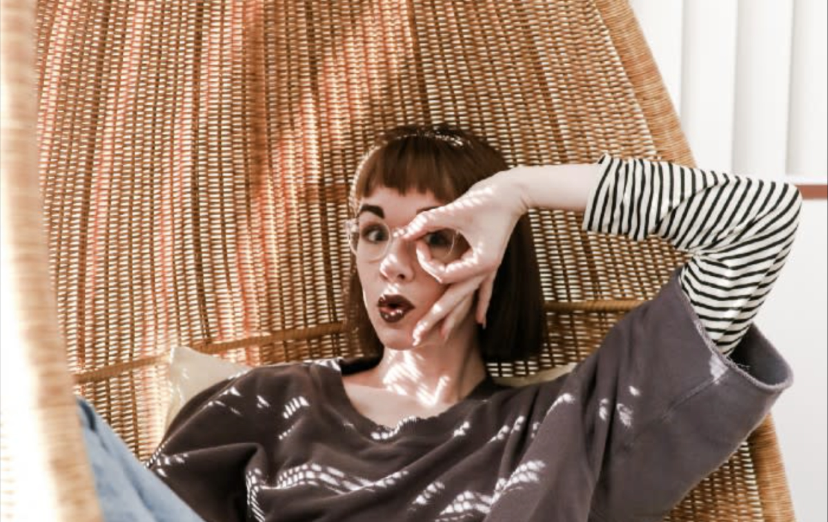 Woman laying in chair with hand in circle