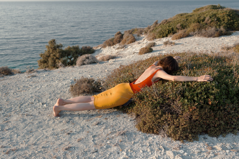 Woman laying on shrubs on the beach