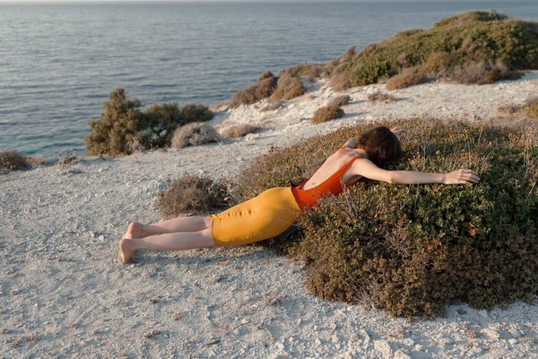 Woman laying on shrubs on the beach