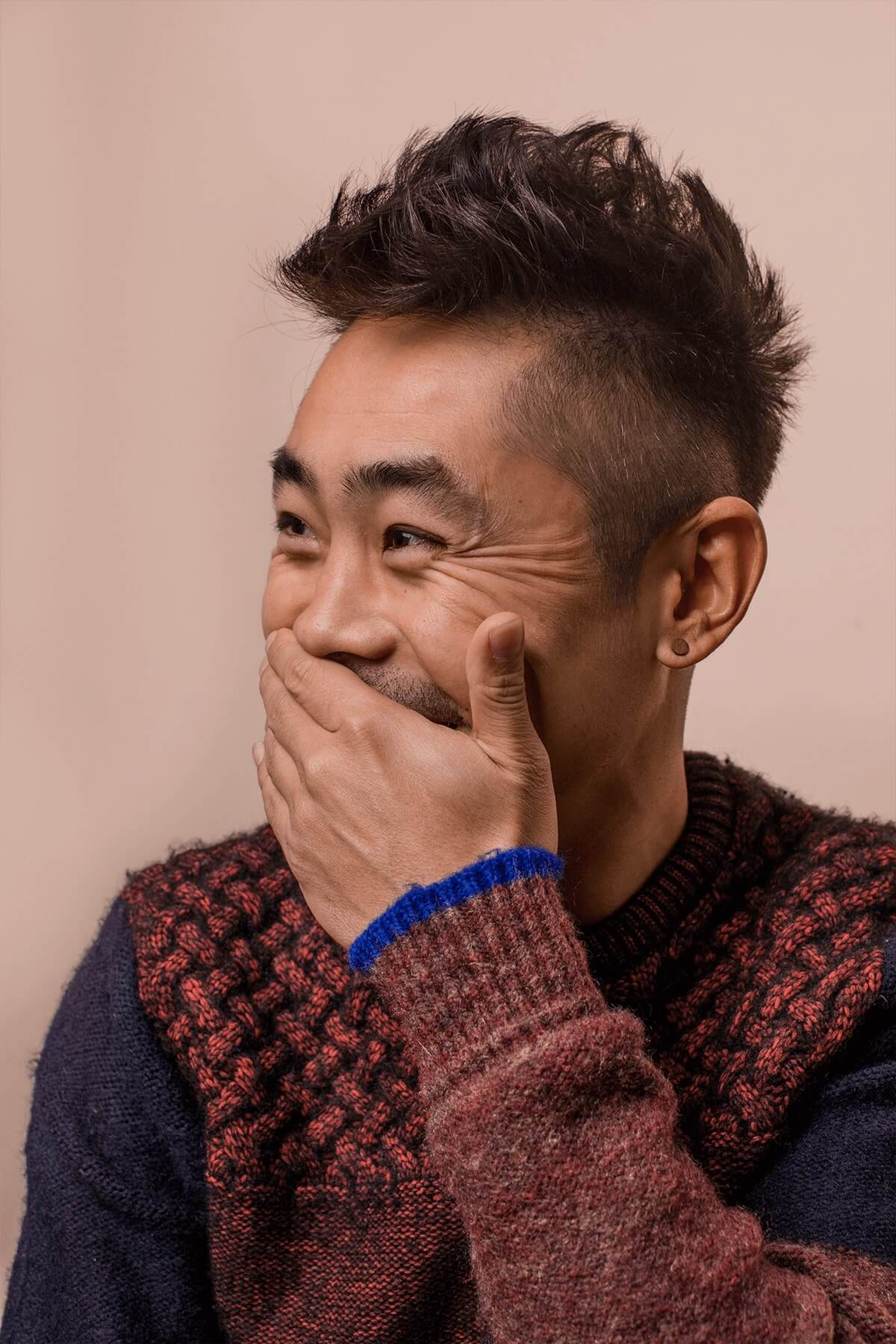 Man covering smile with hand