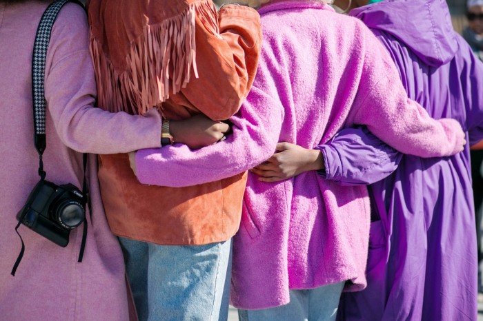 people with purple jackets and arms around eachother