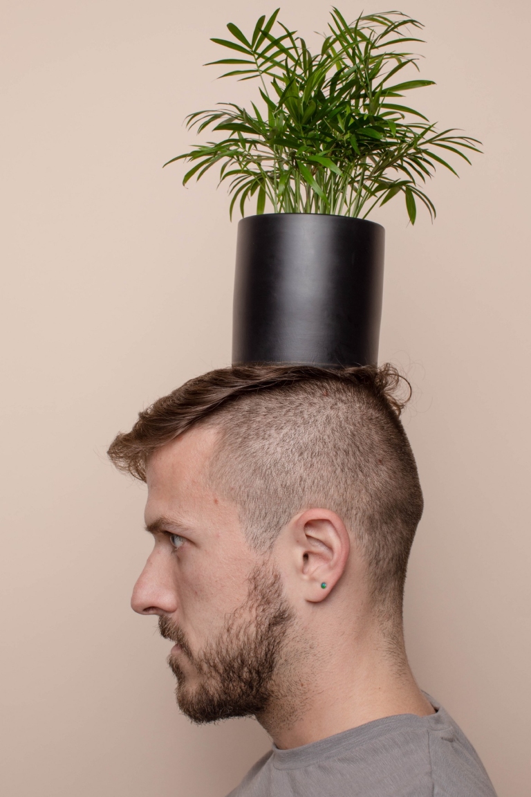 Man balancing plant on his head