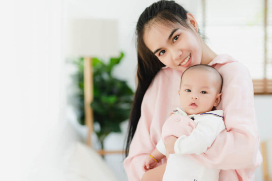 Young Asian Mother Holding Baby