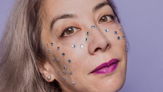 Woman with beads on her face and a purple background