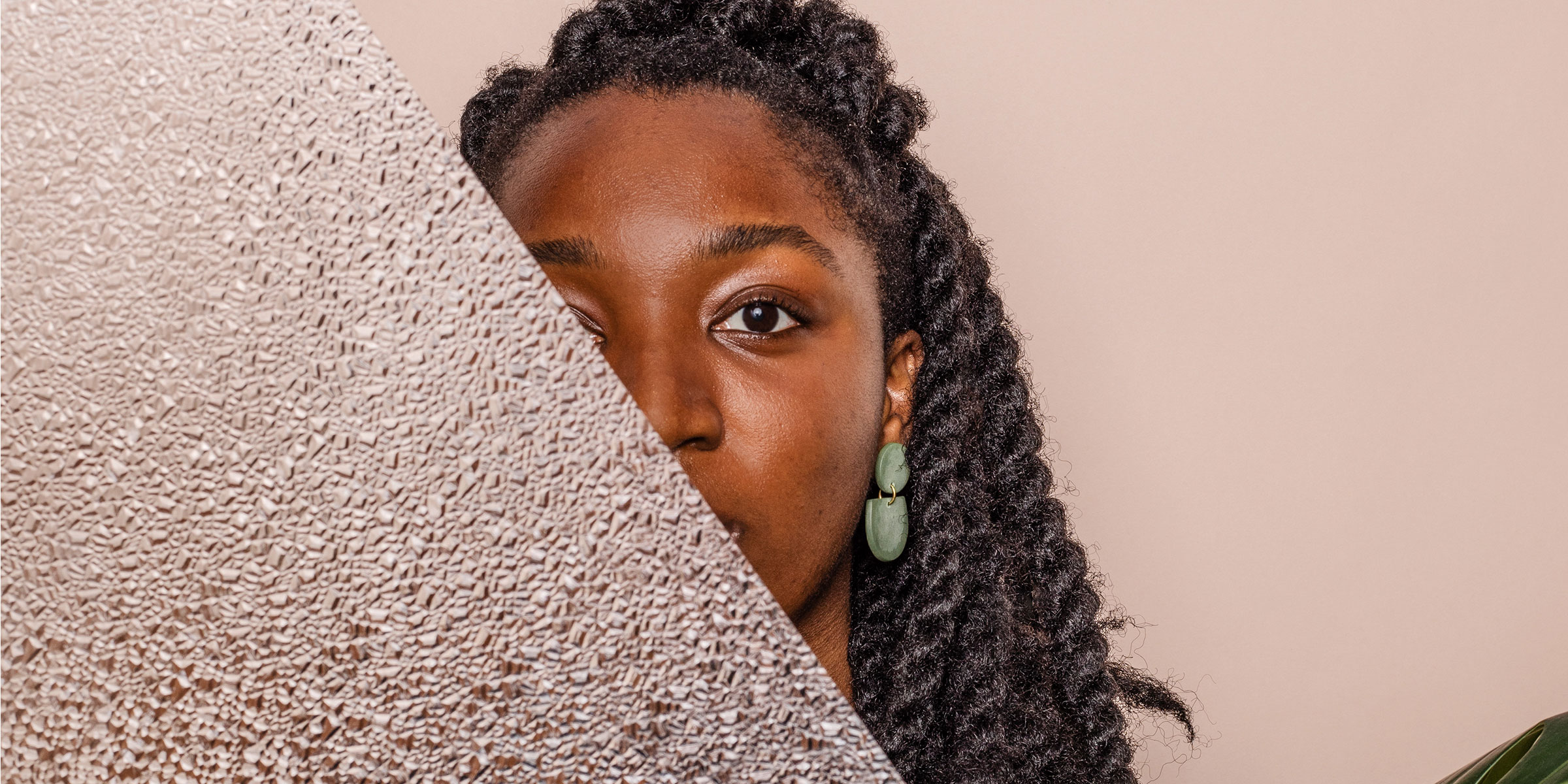 A woman's face, half-obscured by a diagonal slab of plexiglass
