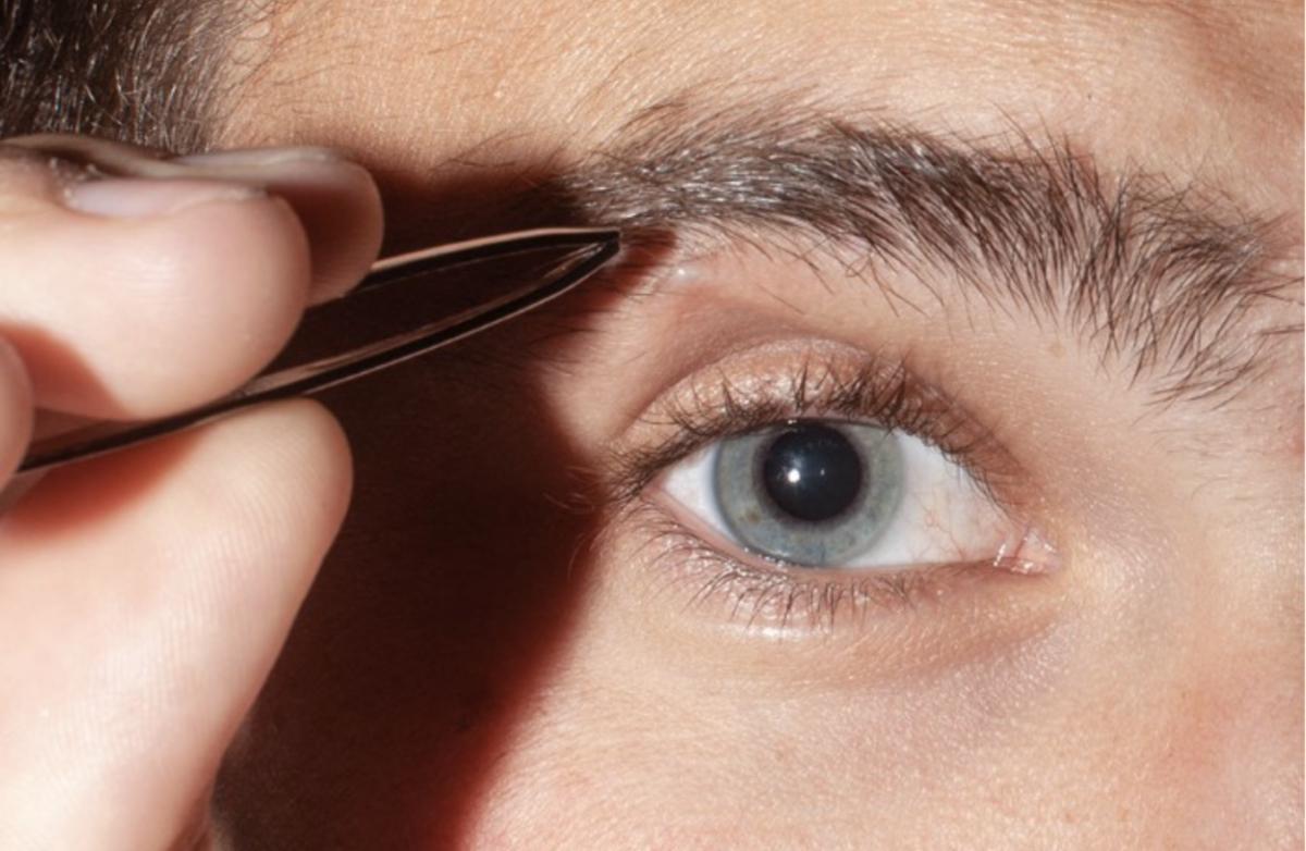 Closeup of person plucking eyebrows
