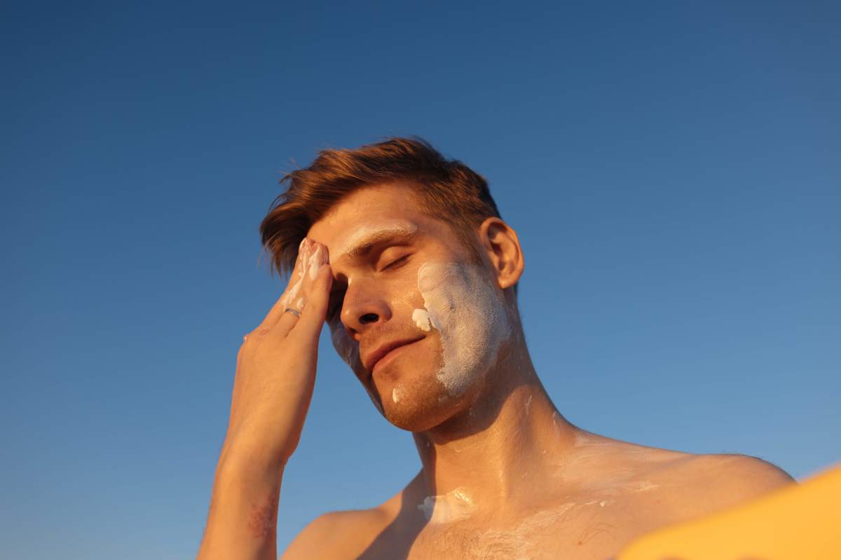 man-applying-sunscreen-on-his-face 