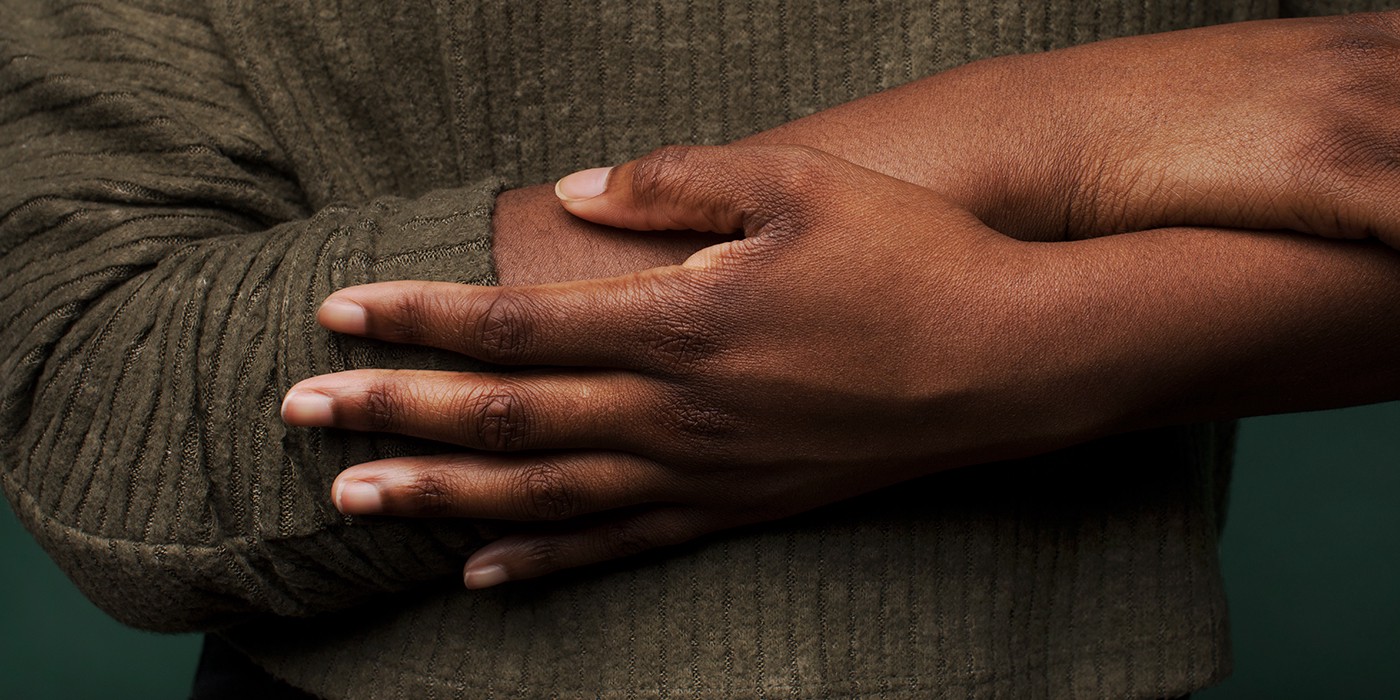 Hands touching arms with green sweater
