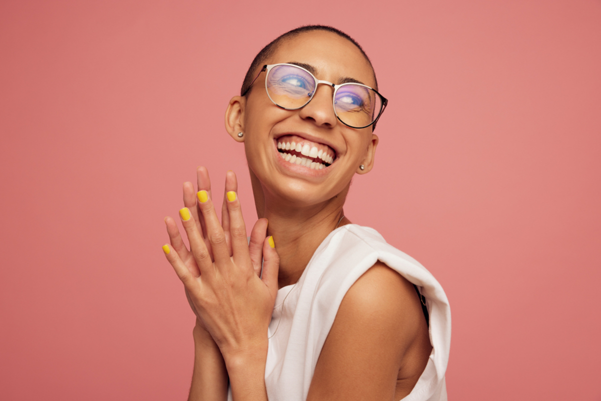 Shaved head woman smiling