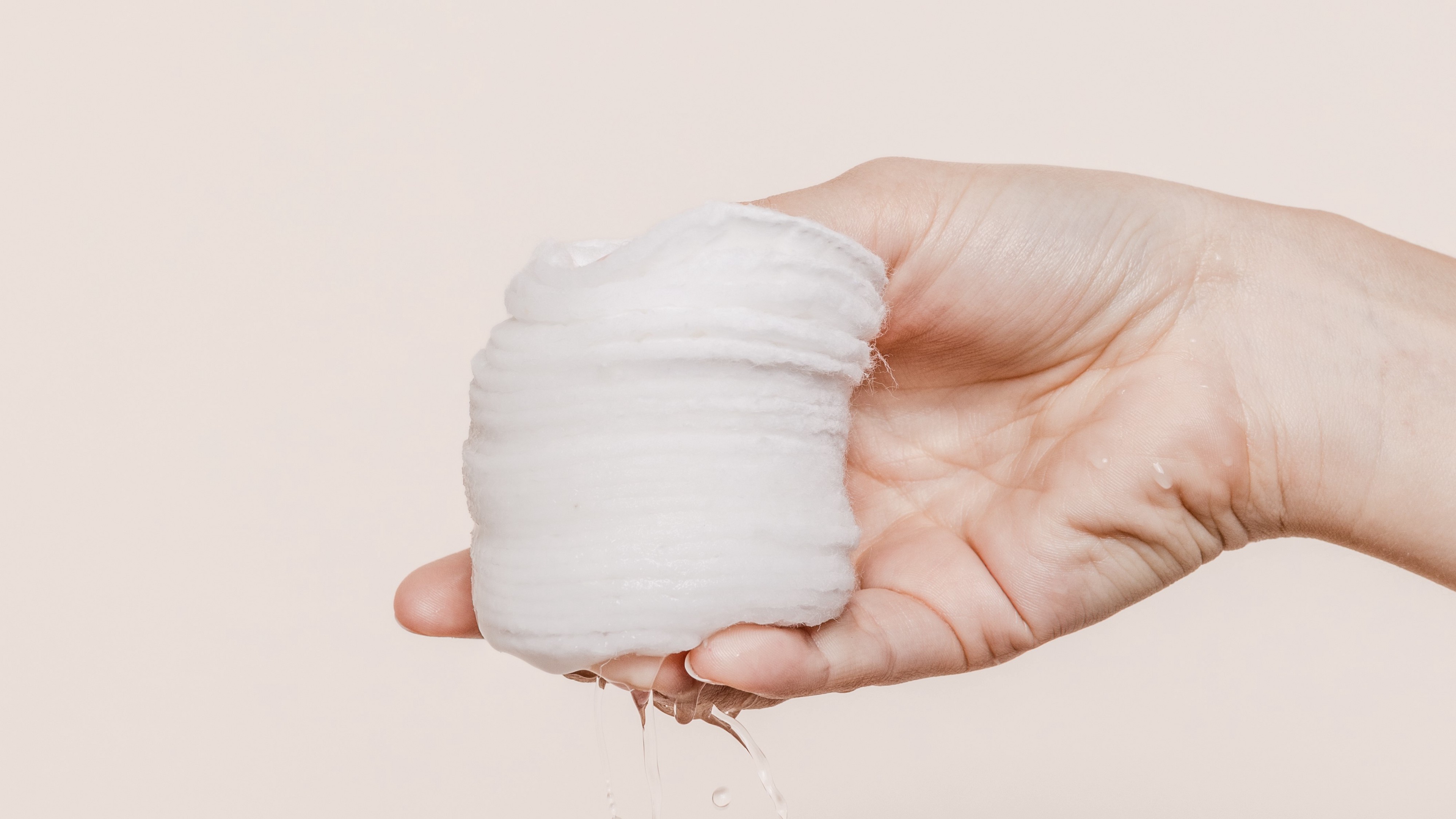 Person holding wet cotton pads
