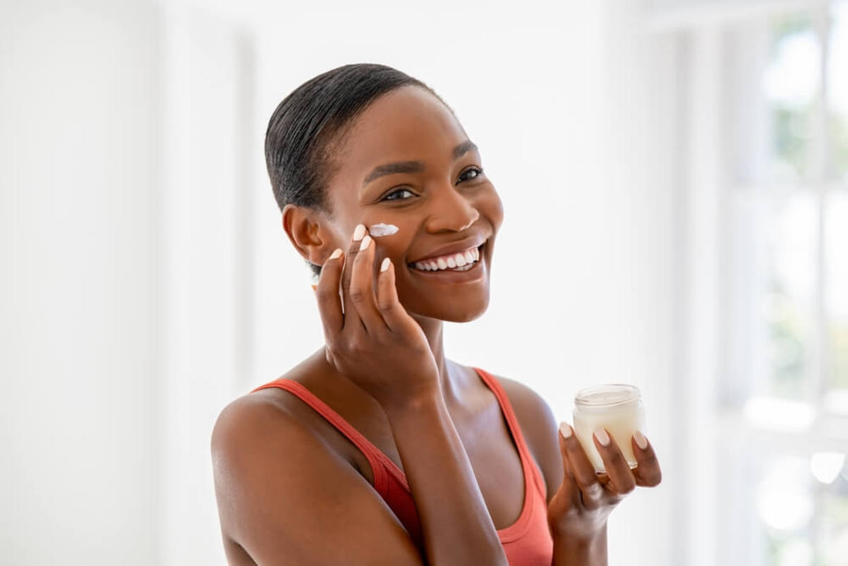 Smiling Woman Applying Moisturizer