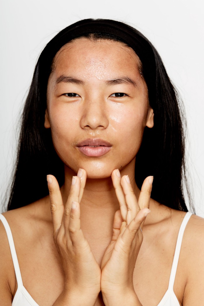 Person rubbing skincare cream on chin