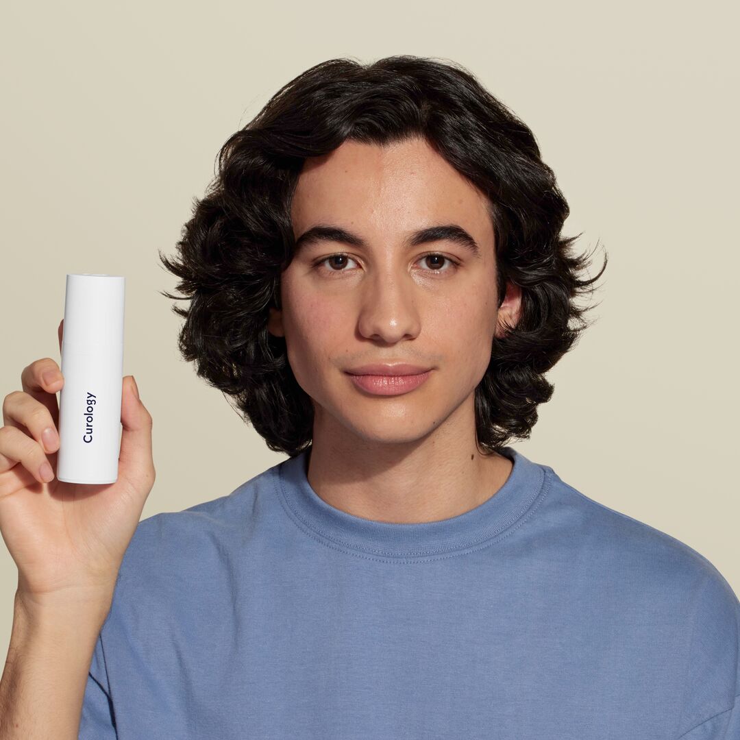 young man holding bottle of custom formula to face