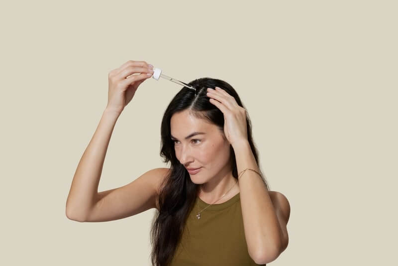 Brunette applying hair treatment