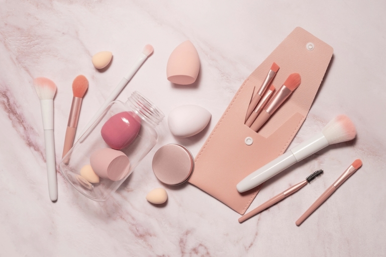 Makeup artist's tools in pink on a marble dressing table