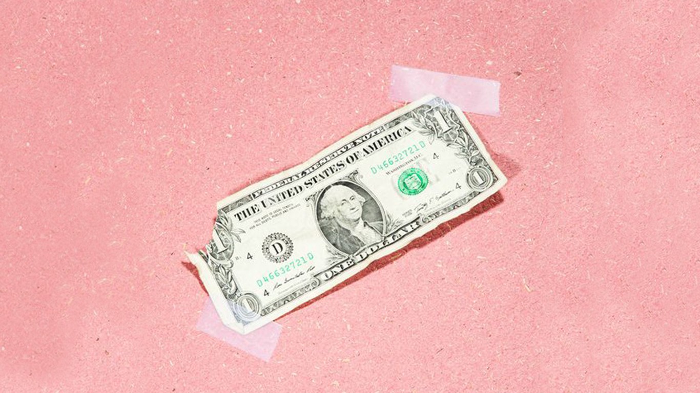 Dollar bill taped to a pink surface