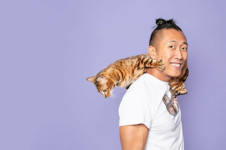 Man with cat on his shoulder with purple background