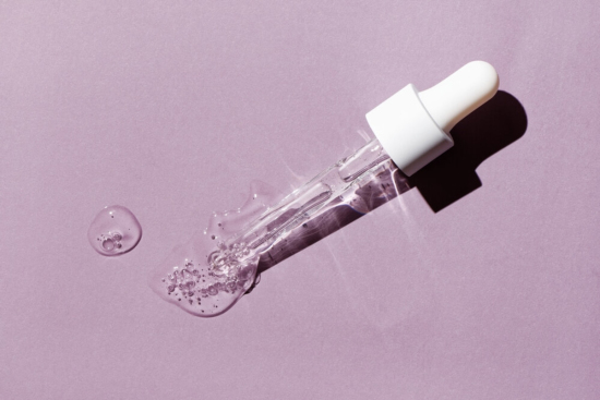 Liquid Oil Serum Drop in Pipette Isolated on Pastel Violet Background