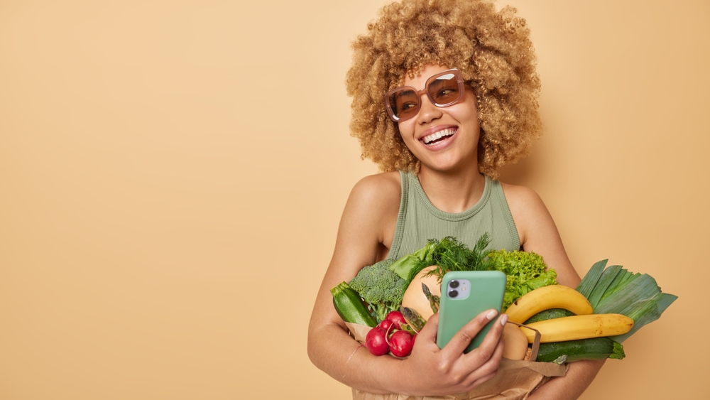 woman with grocery shops and phone